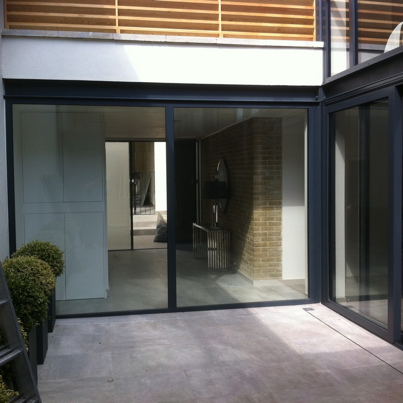 Floor-to-ceiling sliding doors opening to courtyard in Mile End