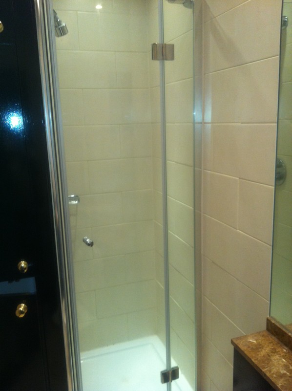 Frameless glass shower enclosure with chrome fittings in Mile End
