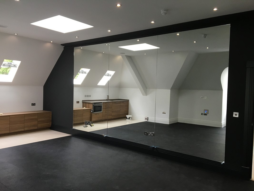 Frameless glass wall dividing loft conversion in Mile End